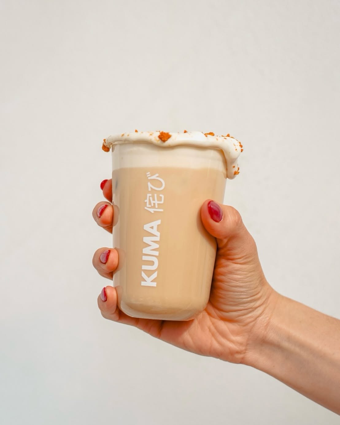 Latte de Kuma Coffee en vaso con logo